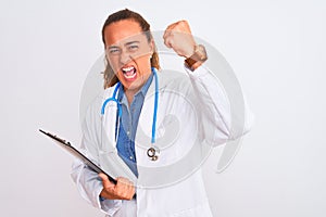 Middle age mature doctor woman holding clipboard over isolated background annoyed and frustrated shouting with anger, crazy and