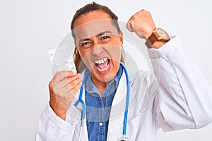 Middle age mature doctor woman showing prescription pills over isolated background annoyed and frustrated shouting with anger,