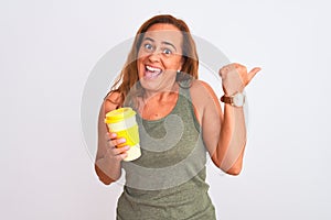 Middle age mature woman drinking a take away cup of coffee over isolated background pointing and showing with thumb up to the side