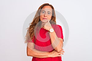 Middle age mature woman standing over white isolated background looking confident at the camera with smile with crossed arms and