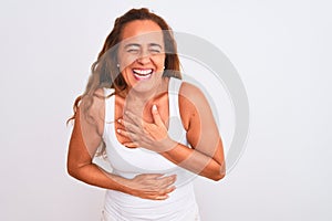 Middle age mature woman standing over white isolated background smiling and laughing hard out loud because funny crazy joke with