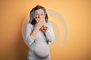 Middle age pregnant woman expecting baby at aged pregnancy shocked covering mouth with hands for mistake