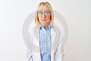 Middle age scientist woman wearing glasses standing over isolated white background with serious expression on face