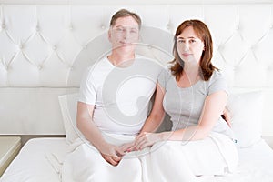 Middle age senior couple in bed. Template and blank t shirt. Front view. Healthy relationships. Copy space