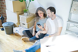 Middle age senior couple moving to a new home using smartphone with a confident expression on smart face thinking serious