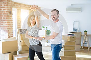 Middle age senior couple moving to a new house, dancing and smiling happy in love with apartmant