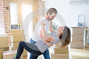 Middle age senior couple moving to a new house, dancing and smiling happy in love with apartmant