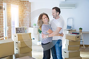 Middle age senior couple moving to a new house, smiling happy in love with apartmant