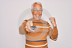 Middle age senior grey-haired man using tv remote control watching television screaming proud and celebrating victory and success