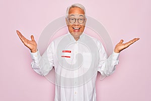 Middle age senior grey-haired man wearing hello my name is introduction sticker very happy and excited, winner expression