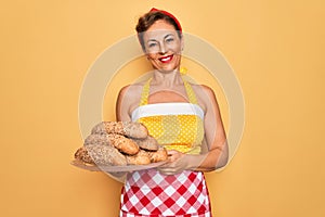 Middle age senior housewife pin up woman wearing 50s style retro dress cooking wholemeal bread with a happy face standing and