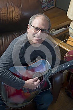 Middle age senior man playing acoustic guitar