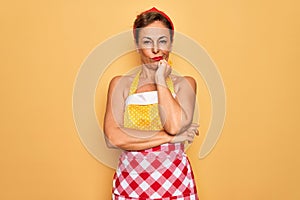 Middle age senior pin up housewife woman wearing 50s style retro dress and apron thinking looking tired and bored with depression