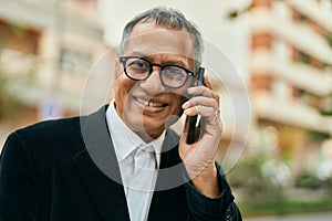 Middle age southeast asian man smiling speaking on the phone at the city