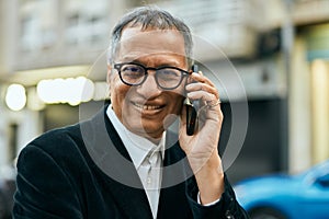 Middle age southeast asian man smiling speaking on the phone at the city