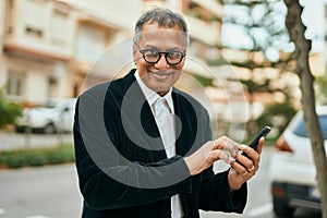 Middle age southeast asian man smiling using smartphone at the city