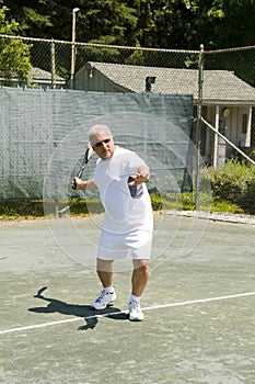 Middle age tennis player forehand on court