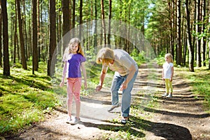 Middle age woman applying insect repellent to her granddaughter before forest hike beautiful summer day. Protecting children from