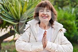 Middle age woman doing yoga exercise at park