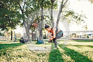 Middle age woman doing yoga in park outside on sunset