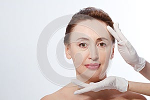 Middle age woman getting spa treatment. Face massage. Anti aging botox and collagen. Plastic surgery concept with doctor hands iso