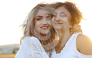 Middle age woman with her adult daughter in sunset light