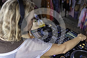 Middle age woman playing music as disk jokey in a beautiful location on the Caparica beach in Lisbon, Portugal. Playful woman photo