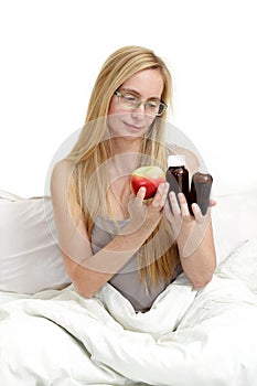 Middle age woman real portrait bed bedroom blonde long hair fifty plus copy space 50 blanket pillow face glasses medical assistanc