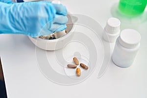 Middle age woman scientist mixing pills on bowl at laboratory photo