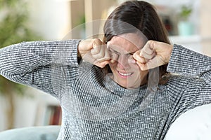 Middle age woman scratching itchy eyes at home photo