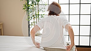 Middle age woman sitting on bed wearing pyjama at bedroom