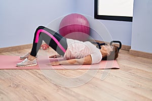 Middle age woman smiling confident training abs exercise at sport center