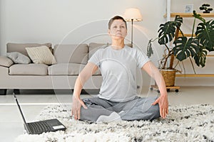 Middle age woman smiling happy doing exercise and stretching at home
