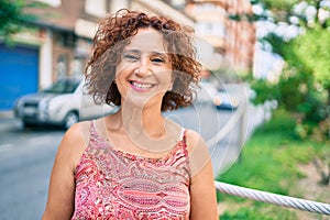 Middle age woman smiling happy walking at street of city