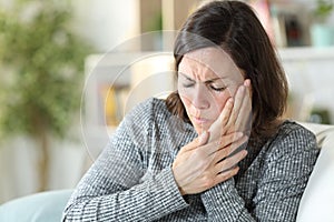 Middle age woman suffering toothache at home