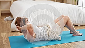 Middle age woman training abs exercise at bedroom