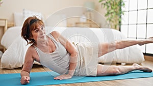 Middle age woman training legs exercise at bedroom