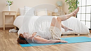Middle age woman training legs exercise at bedroom
