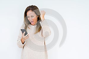 Middle age woman using smartphone over isolated background annoyed and frustrated shouting with anger, crazy and yelling with