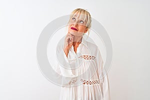 Middle age woman wearing casual shirt standing over isolated white background with hand on chin thinking about question, pensive