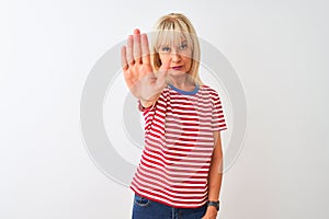 Middle age woman wearing casual striped t-shirt standing over isolated white background doing stop sing with palm of the hand