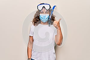 Middle age woman wearing coronavirus protection mask and diving gogles glasses as canceled vacation pointing thumb up to the side