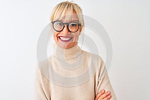 Middle age woman wearing turtleneck sweater and glasses over isolated white background happy face smiling with crossed arms