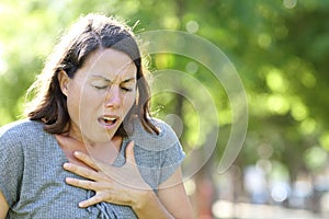 Middle age woman wheezing in a park