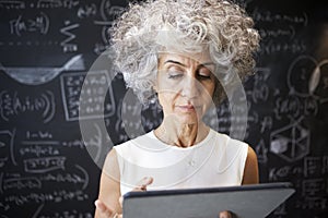 Middle aged academic woman using tablet, close up