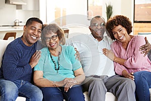 Middle aged African American  couple and parents sitting at home, smiling to camera