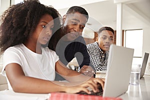 Middle aged African American  dad helping his teen kids with homework, low angle, close up