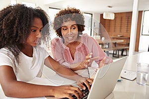 Middle aged African American  woman helping her teenage daughter with homework, close up