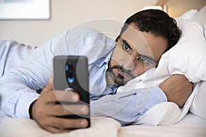 Middle aged arab man in bed with his phone