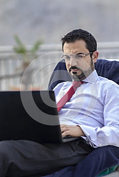 Middle aged arab man by a pool in his business attire